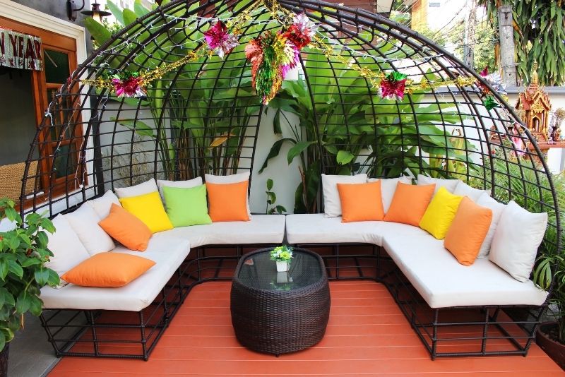 multi-sitted birdcage sofa with colorful pillows in a patio area